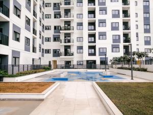 an apartment building with a pool in front of it at Nasma Luxury Stays - Home-Style 2BR Apartment with a Balcony View in Dubai