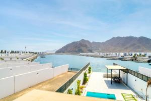 - une vue sur l'eau depuis le balcon d'un bâtiment dans l'établissement Luxury 4BR Villa with Assistant’s Room Al Dana Island, Fujairah by Deluxe Holiday Homes, à Fujaïrah