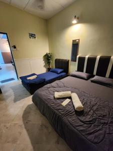 a bedroom with a large bed with a towel on it at Sun Star Home by Ipoh Maju Stay in Ipoh