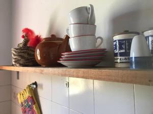 a shelf with plates and cups on top of it at Casa rural junto al Río Chubut (Ty'r Bont) Trelew in Trelew