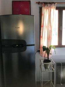 a stainless steel refrigerator in a kitchen with a potted plant at Casa rural junto al Río Chubut (Ty'r Bont) Trelew in Trelew