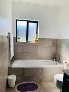 a bathroom with a bath tub and a window at Private Deluxe Bedroom with Backup Power in Johannesburg
