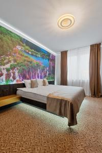 a bedroom with a large painting on the wall at Fit Residence in Cluj-Napoca