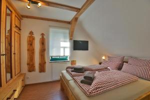 um quarto com uma cama com um cobertor xadrez vermelho e branco em Ferienhaus Chalet zur Werraquelle em Masserberg