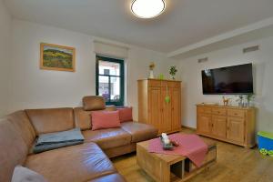 a living room with a couch and a flat screen tv at Ferienhaus Chalet zur Werraquelle in Masserberg