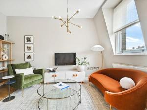 un soggiorno con 2 sedie e una TV di Mayfair Luxury Apartment Sleeps 6 people a Londra