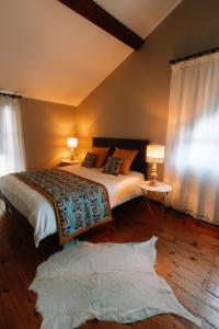 a bedroom with a bed with a rug on the floor at Domaine de la Serve in Lancié