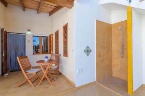 a bathroom with a table and chairs and a shower at Garonda Villa in Cala Pi