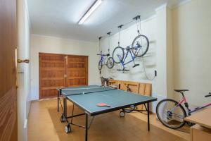 a ping pong table in a room with two bikes at Garonda Villa in Cala Pi