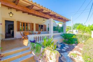 a house with a porch and stairs to a patio at Garonda Villa in Cala Pi