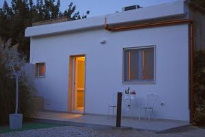 een wit huis met een tafel en stoelen ervoor bij Alchimia SPA & Centro Benessere in Mesagne