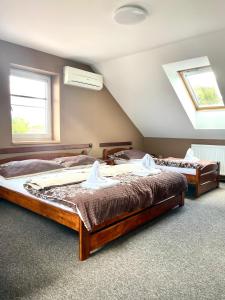 2 camas en una habitación con 2 ventanas en Penzion a restaurace U Nováků, en Bítovany