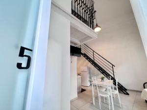 sala de estar con escalera, mesa y sillas en 8 Lofts - Apartments, en La Spezia