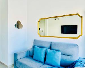 Sofá azul en la sala de estar con espejo en Canaryislandshost l Cala, en Punta Mujeres