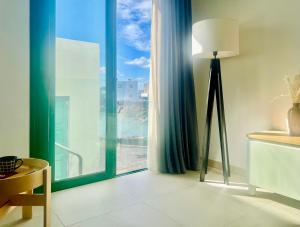 a room with a floor lamp and a large window at Canaryislandshost l Cala in Punta de Mujeres
