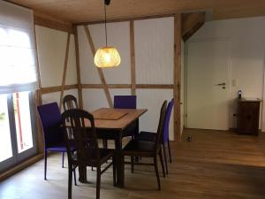 una sala da pranzo con tavolo e sedie in legno di Ferienhaus "Am Saarbach" a Ochsenfurt