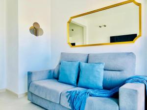 Sofá azul en la sala de estar con espejo en Canaryislandshost l Cala, en Punta Mujeres