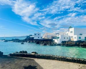 uma vista para uma praia com edifícios brancos e a água em Canaryislandshost l Cala em Punta Mujeres