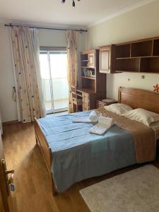 una camera da letto con un grande letto con una coperta blu di Quinta da Casinha Homestay a Pombal