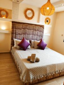 a bedroom with a large bed with purple pillows at Incantevole villa Safi Sidi Bouzid near beach in Safi