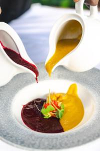 a cup of sauce being poured into a plate of food at Zanzibar Queen Hotel in Matemwe