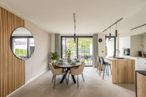 a kitchen and dining room with a table and chairs at NIEUW - De Grenspaal WEST 6P 5 min Maastricht - Sauna - Laadpaal in Riemst