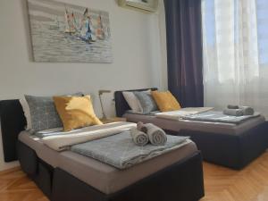 2 Betten im Wohnzimmer mit Handtüchern darauf in der Unterkunft Despot Apartmani Niš in Niš