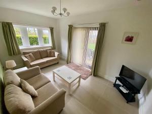 sala de estar con sofá y TV en Calder Cottage in The Ribble Valley en Whalley
