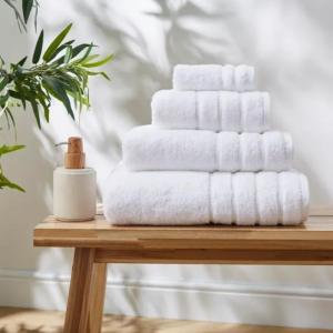 una pila di asciugamani seduta su un tavolo di legno di Mayfair Luxury Apartment Sleeps 6 people a Londra