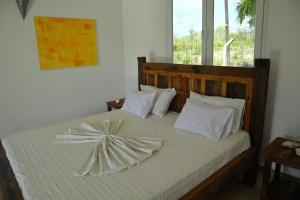 una camera da letto con un grande letto con cuscini bianchi di Holiday Time Bungalows Sansibar a Gazija