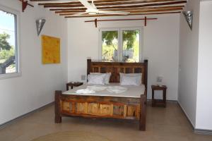 una camera con letto in legno di Holiday Time Bungalows Sansibar a Gazija