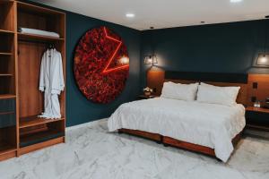 een slaapkamer met een bed en een muur met een spiegel bij Hotel Casa Puga in Oaxaca City