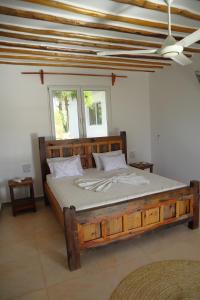 1 dormitorio con 1 cama grande de madera en una habitación en Holiday Time Bungalows Sansibar, en Gazija