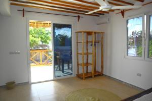 a room with a ceiling fan and a room with sliding glass doors at Holiday Time Bungalows Sansibar in Gazija