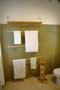 a bathroom with white towels hanging on a green wall at Holiday Time Bungalows Sansibar in Gazija
