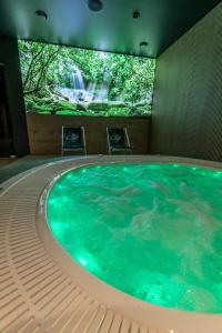 uma grande piscina de água num quarto com uma cascata em Hotel Fox em Wolbórz