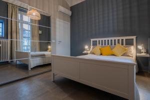 een slaapkamer met een groot bed met gele kussens bij Einaudi Apartment by Wonderful Italy in Turijn