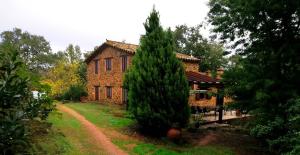 una casa con un gran árbol delante de ella en FINCA LA LISERILLA, en Galaroza