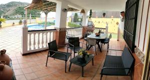 une terrasse avec une table, des chaises et une piscine dans l'établissement cortijo Maria Gomez, à Malaga
