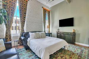 - un salon avec un lit et une télévision dans l'établissement Broughton Retreat, à Savannah