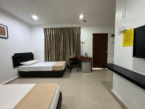 a bedroom with a bed and a table and a desk at Lan Village in Mersing