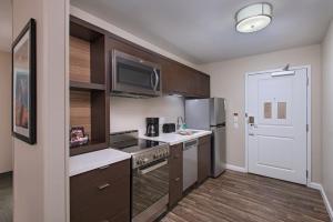 a kitchen with brown cabinets and a microwave at TownePlace Suites by Marriott Lakeland in Lakeland
