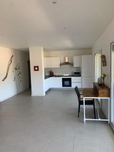 ein Wohnzimmer mit einem Tisch und einer Küche in der Unterkunft Grand appartement T4, piscine, vue exceptionnelle à 50 m de la plage in Propriano