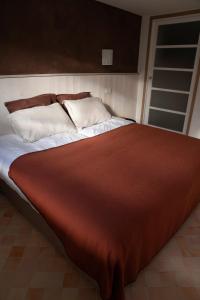 een groot bed met een rode deken en witte kussens bij Charmant Appartement T2 Parking & Terrasse - Crêt de la Roche in Aix-les-Bains