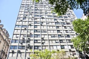 un edificio alto de color blanco con ventanas en Studio Congreso, en Buenos Aires