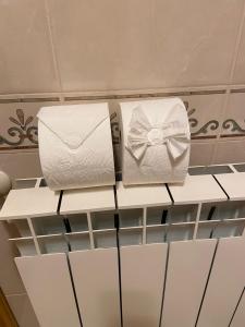 duas toalhas brancas numa prateleira num armário em Quinta da Casinha Homestay em Pombal