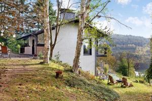 ein Haus auf einem Hügel neben einem Baum in der Unterkunft Ferienhaus Auszeyt für Zwei in Waldeck