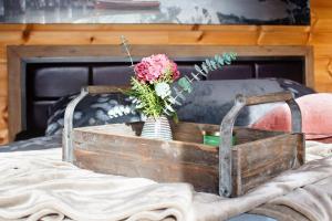 eine Holzkiste mit einer Vase aus Blumen auf dem Bett in der Unterkunft Ferienhaus Auszeyt für Zwei in Waldeck