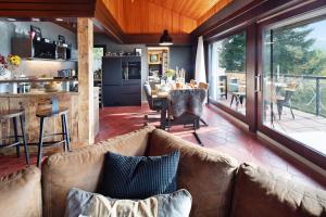 ein Wohnzimmer mit einem Sofa, einer Küche und einem Tisch in der Unterkunft Ferienhaus Auszeyt für Zwei in Waldeck