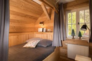 a bedroom with a bed in a wooden cabin at Harzer Wiesenbaude in Braunlage